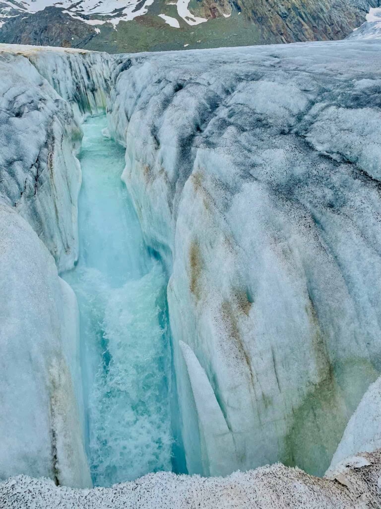 Wasser, dass in eine Gletschermühle auf dem Aletschgletscher fällt.