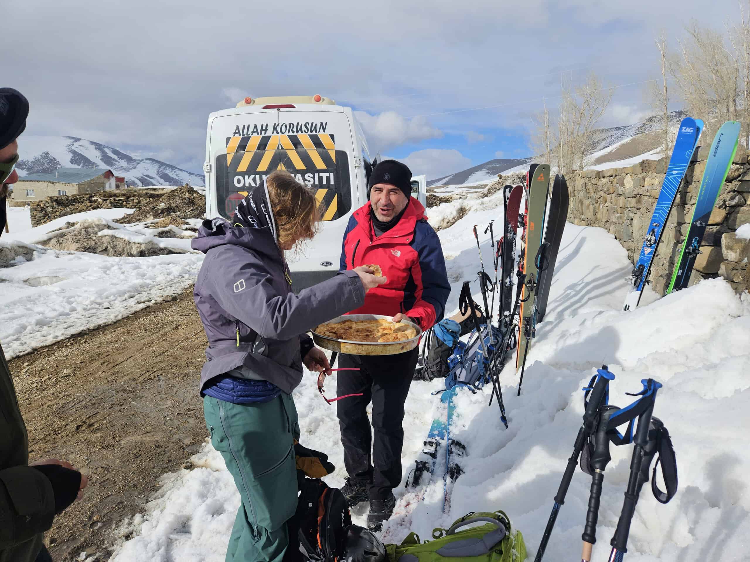 A local driver treats the Bergschaft ski tourers to oven-fresh Turkish börek by the minibus in the snow after a day’s skiing.